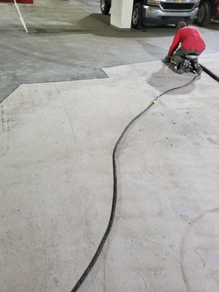 photo of an ESS employee grinding a concrete surface prior to a full resurfacing project