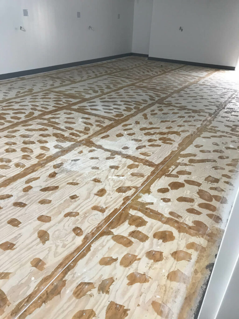 photo of a wood surface with holes and seams patched, ready for a concrete surface